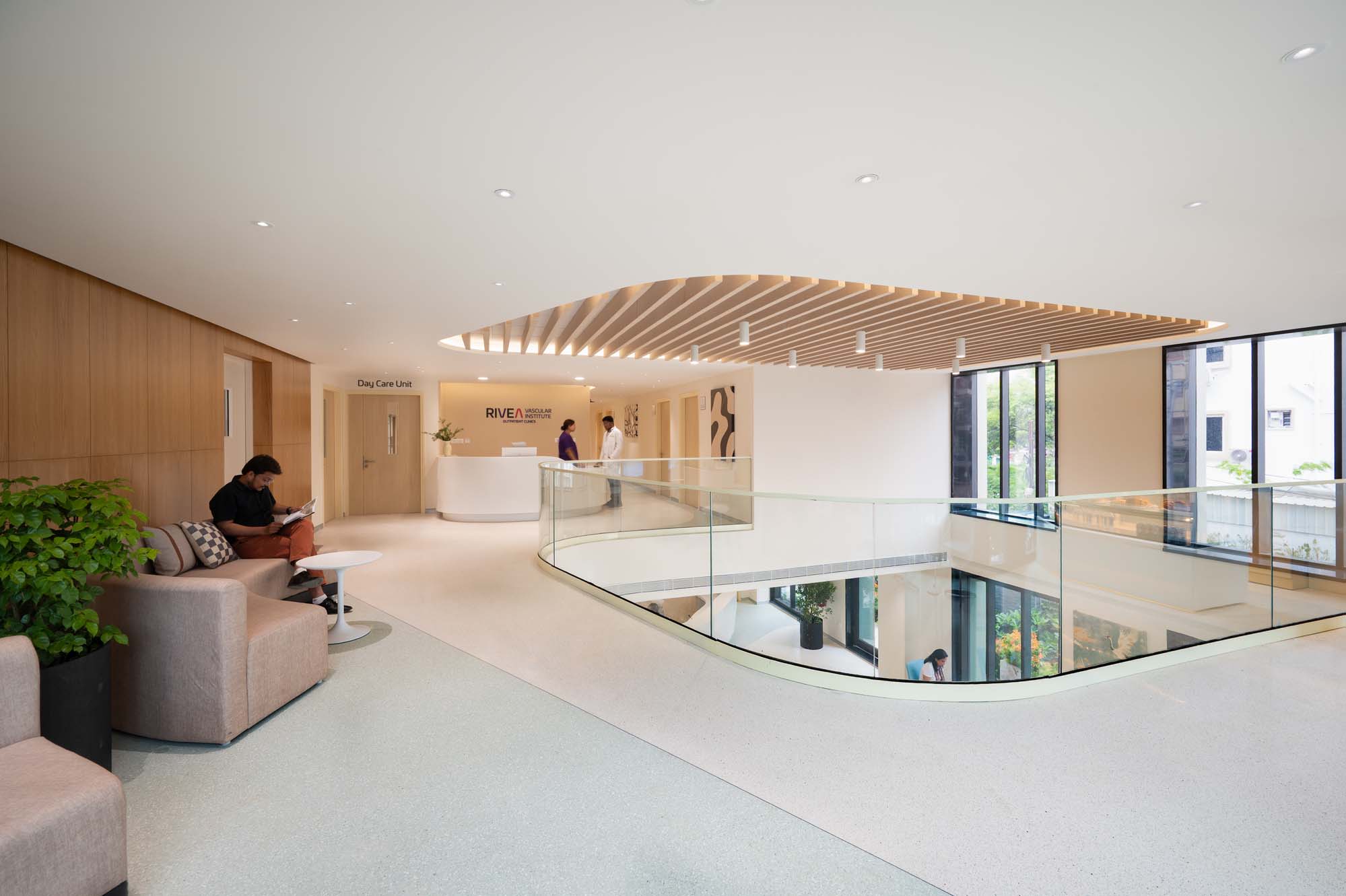 Modern two-level reception area with glass railing and seating at Rivea